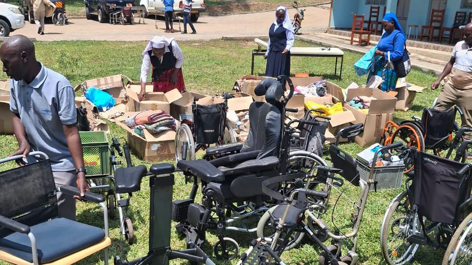 Ordensschwestern und Helfer verteilen Hilfsgüter aus einem Container in Uganda.